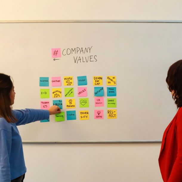 Zwei Teammitglieder erklären gemeinsam an einem Flipchart die Schritte zur Prozessoptimierung, um Effizienz und Abläufe zu verbessern.